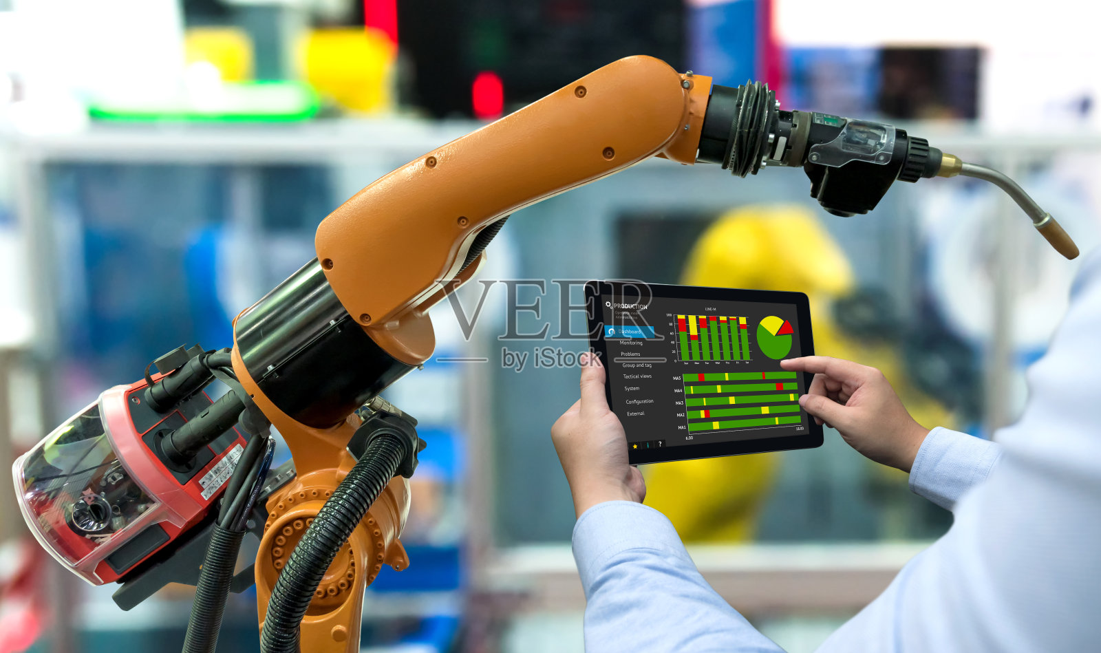 工程师经理手用平板，重型自动化机器人手臂机器在智能工厂工业用平板实时监控生产系统。工业第四物联网概念。照片摄影图片