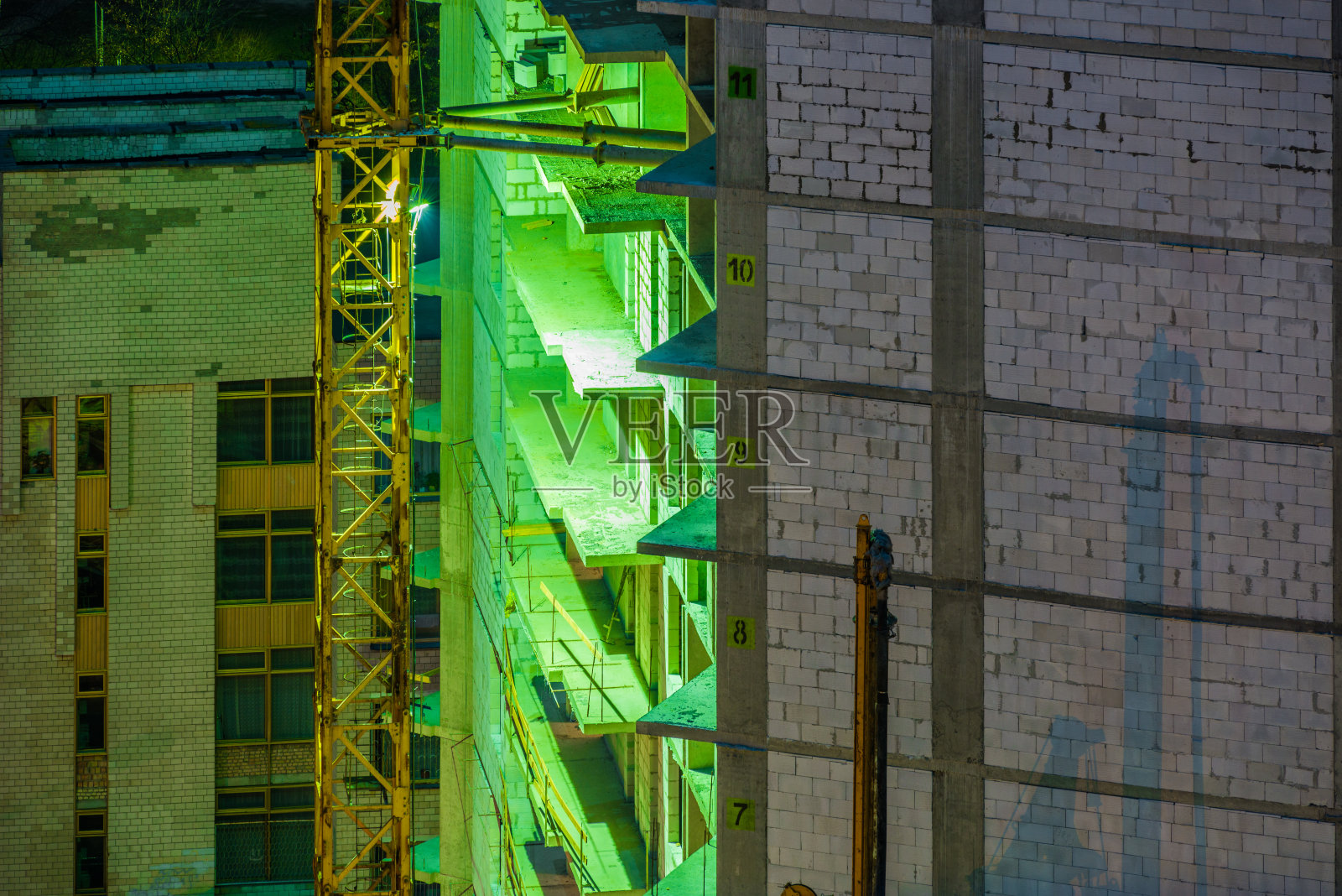 夜间施工用绿色灯光和塔吊照片摄影图片