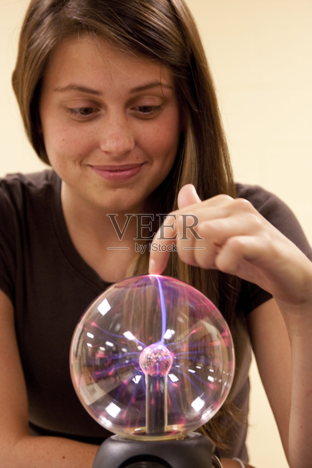 女学生触摸等离子球。照片摄影图片