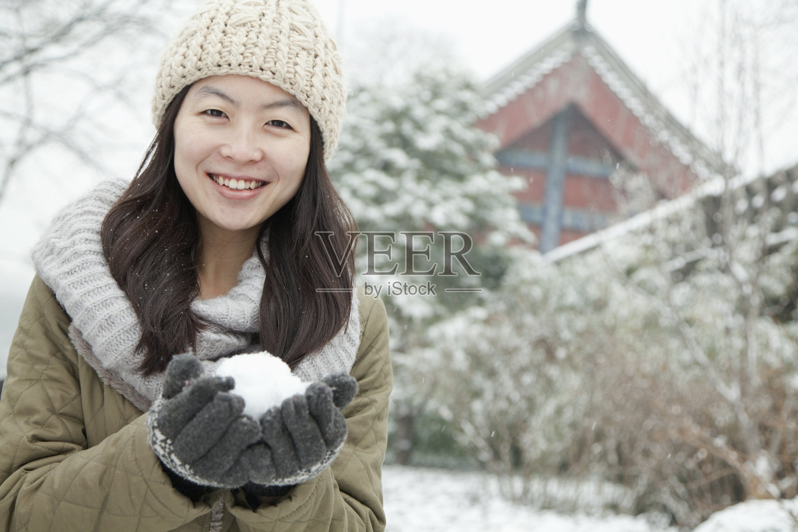 一个女人在公园外面拿着雪球照片摄影图片