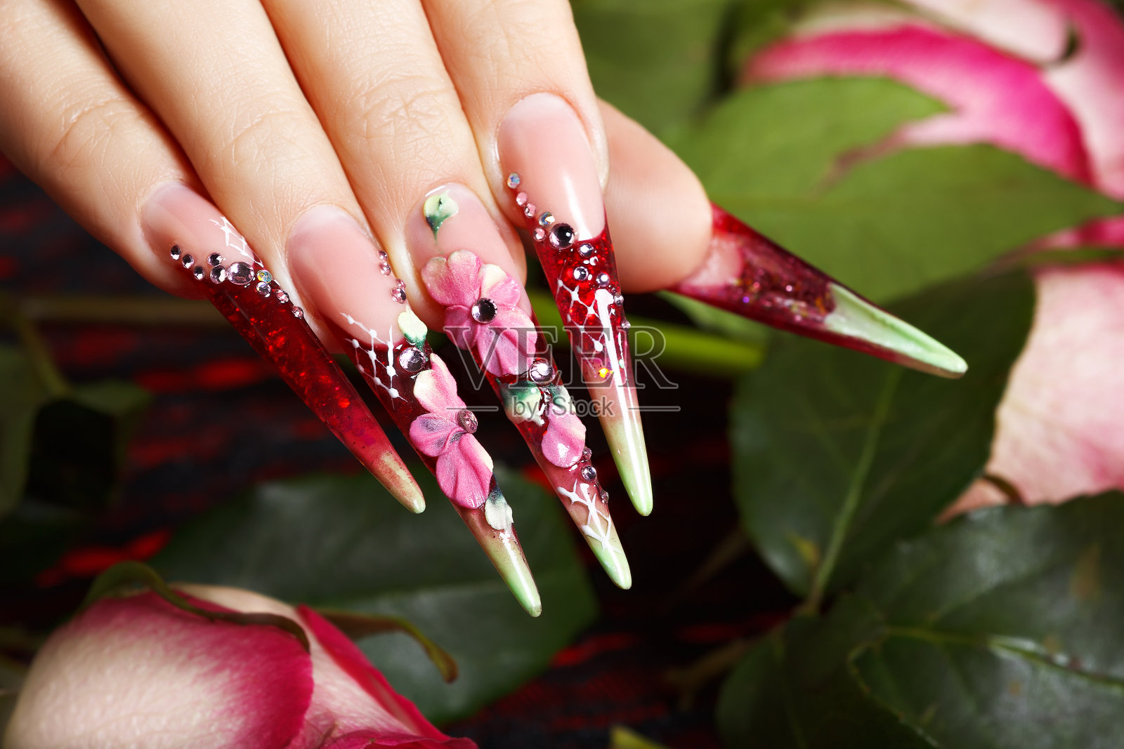 美丽的粉红色花卉设计指甲。照片摄影图片