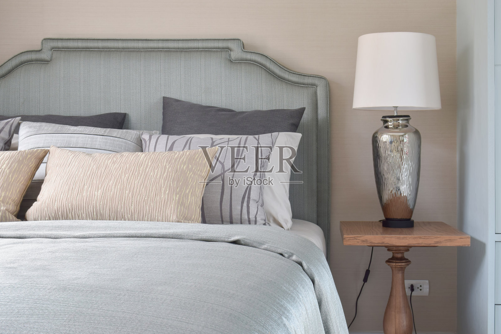 浪漫风格的床上用品:床头柜上的绸缎毯子和台灯照片摄影图片