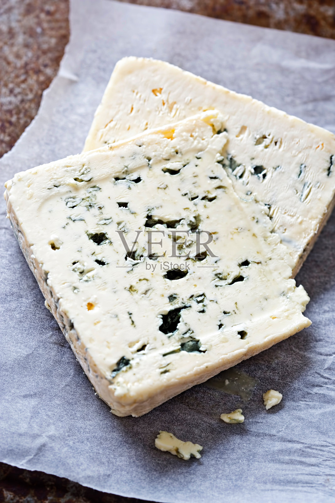 两片蓝奶酪放在白色的羊皮纸上照片摄影图片