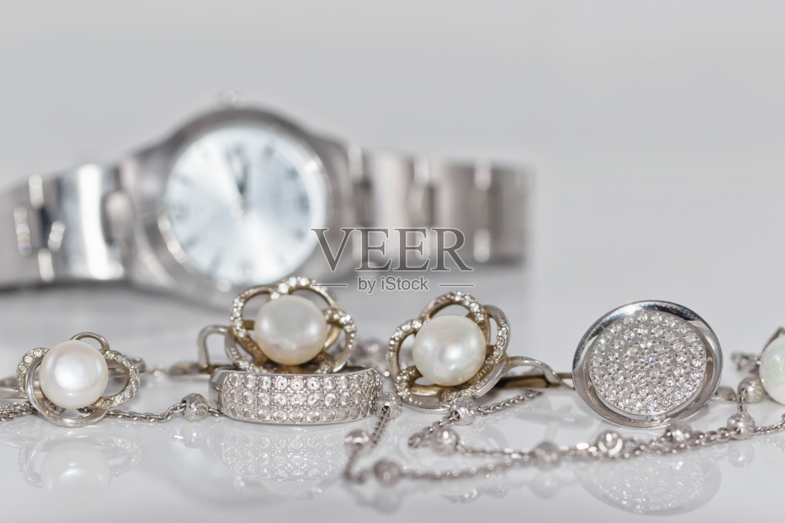 银质耳环与珍珠手表的背景照片摄影图片