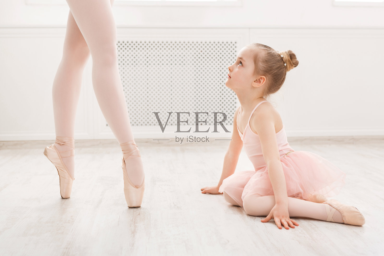 小女孩在看专业的芭蕾舞演员照片摄影图片