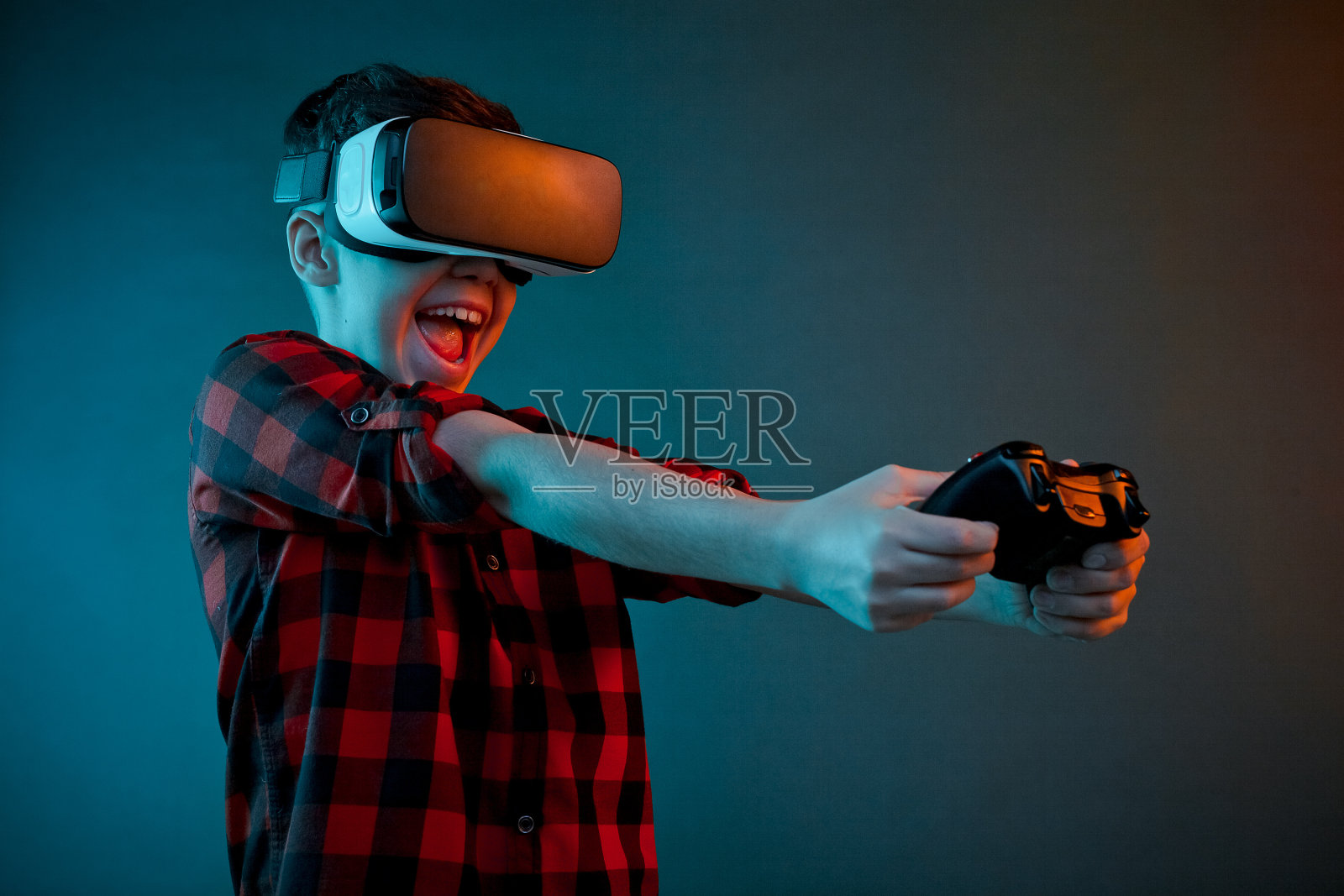兴奋的男孩用VR眼镜玩游戏手柄照片摄影图片