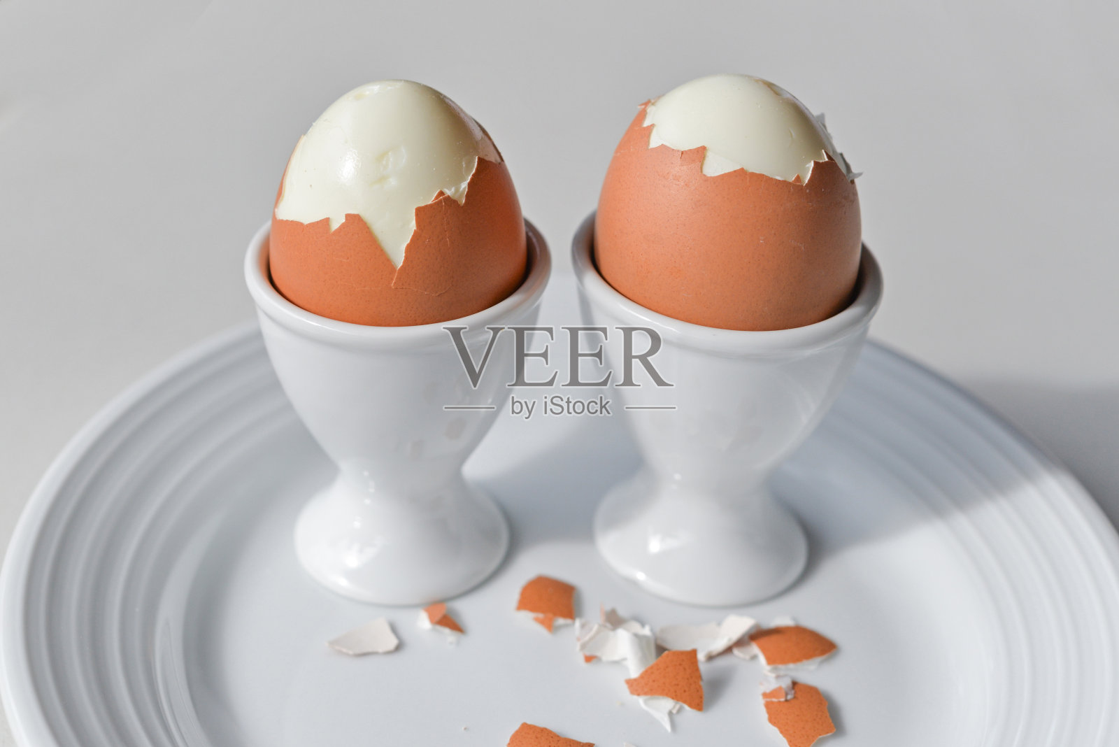 在白色盘子上的鸡蛋杯煮鸡蛋照片摄影图片