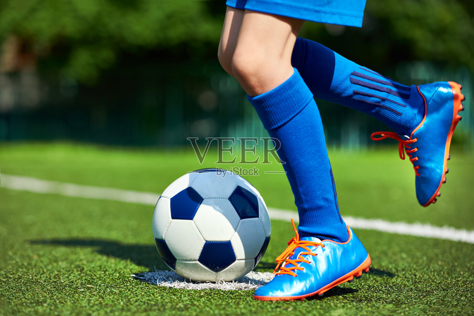 腿足球运动员男孩在草地上穿着皮靴和球照片摄影图片