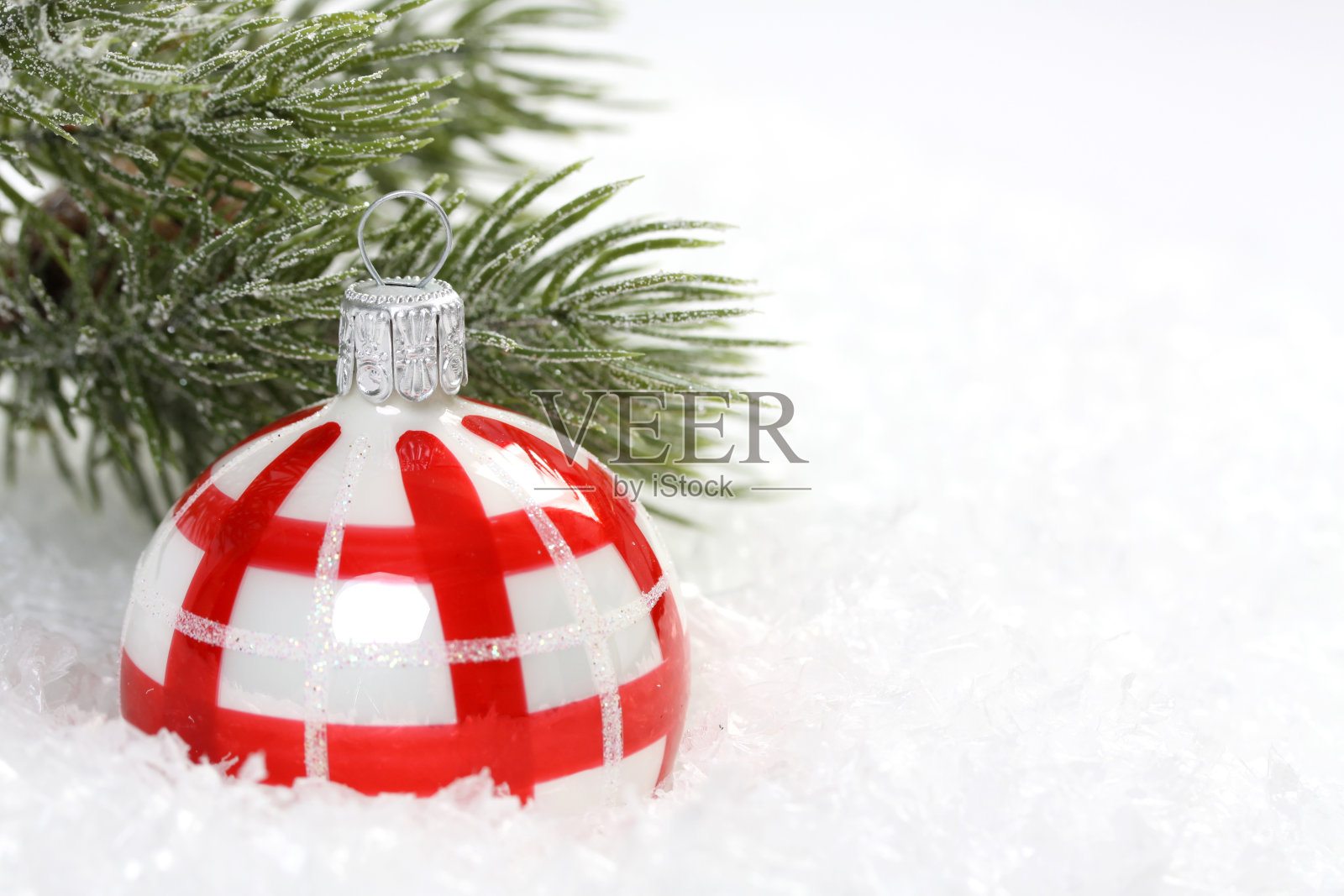 26、红白相间的圣诞球上雪花飞舞，松枝结冰照片摄影图片