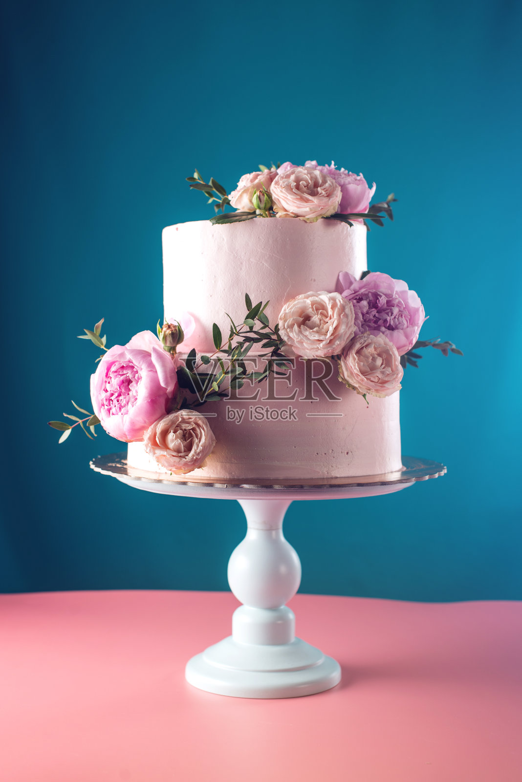 用新鲜玫瑰装饰的粉色奶油婚礼蛋糕照片摄影图片