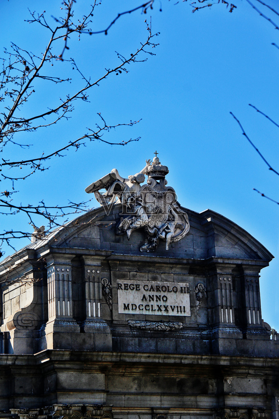由名望(没有他的支持右臂截肢出现的喇叭)和婴儿天才所持有的盾形纹章，位于西班牙马德里Puerta de Alcalá (Alcalá Gate或Citadel Gate)东侧的雕塑照片摄影图片
