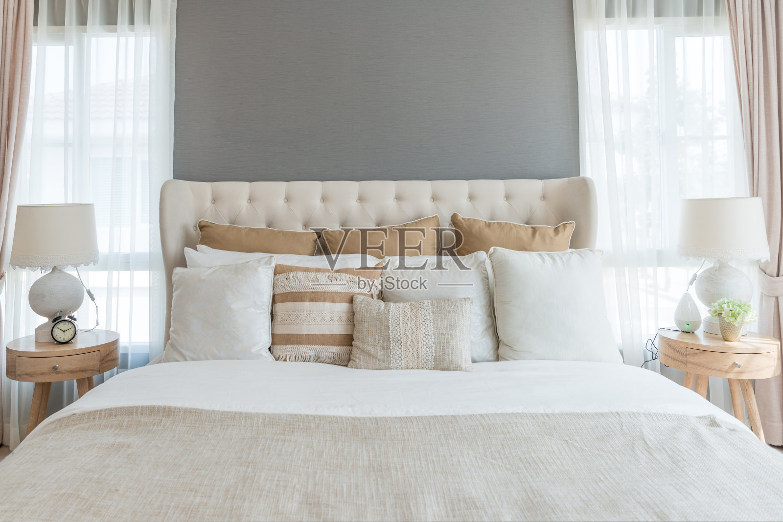 柔和的浅色卧室。舒适的大双人床在优雅的古典卧室在家里。照片摄影图片