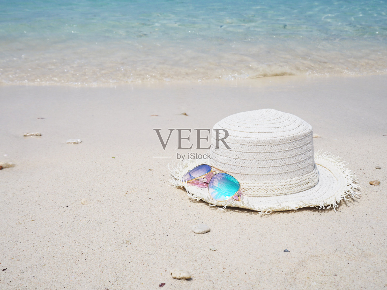 时尚的镜子太阳镜和白色的帽子在沙滩的背景照片摄影图片