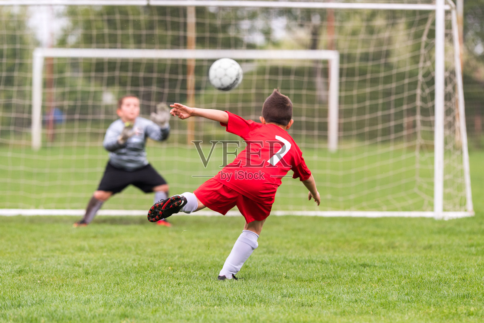 孩子们踢足球——年轻的孩子们在足球场上比赛照片摄影图片
