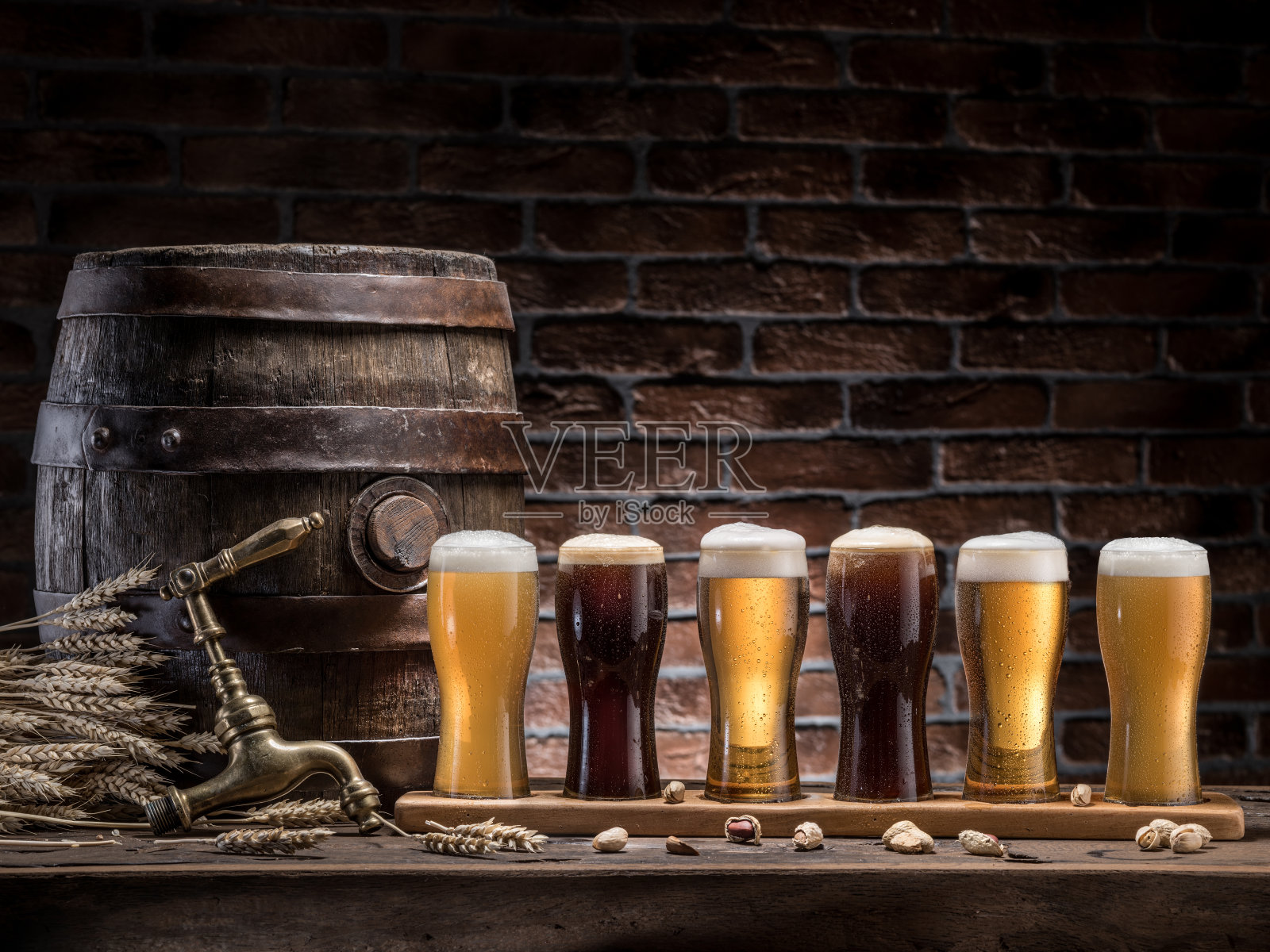 木桌上摆着一桶桶啤酒和麦酒。工艺啤酒。照片摄影图片