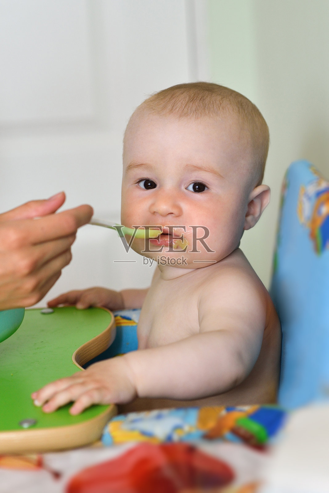 母亲在家里厨房给男婴喂奶照片摄影图片