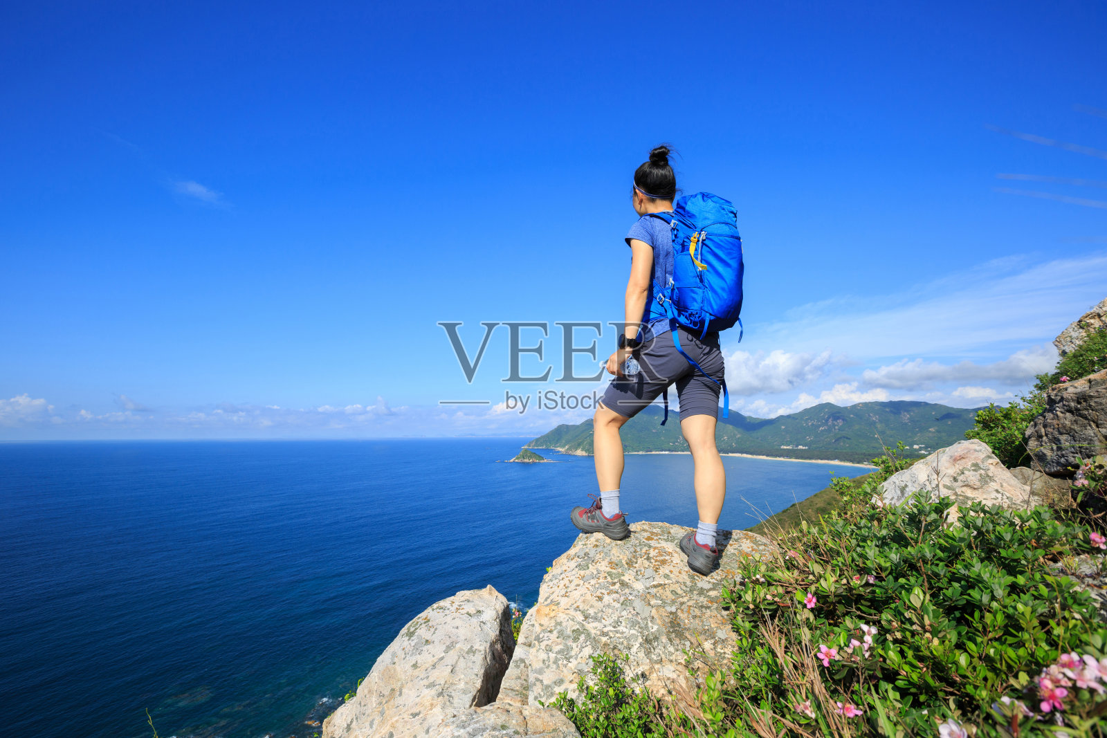 成功的女背包客喜欢海边的风景，高山的岩石照片摄影图片