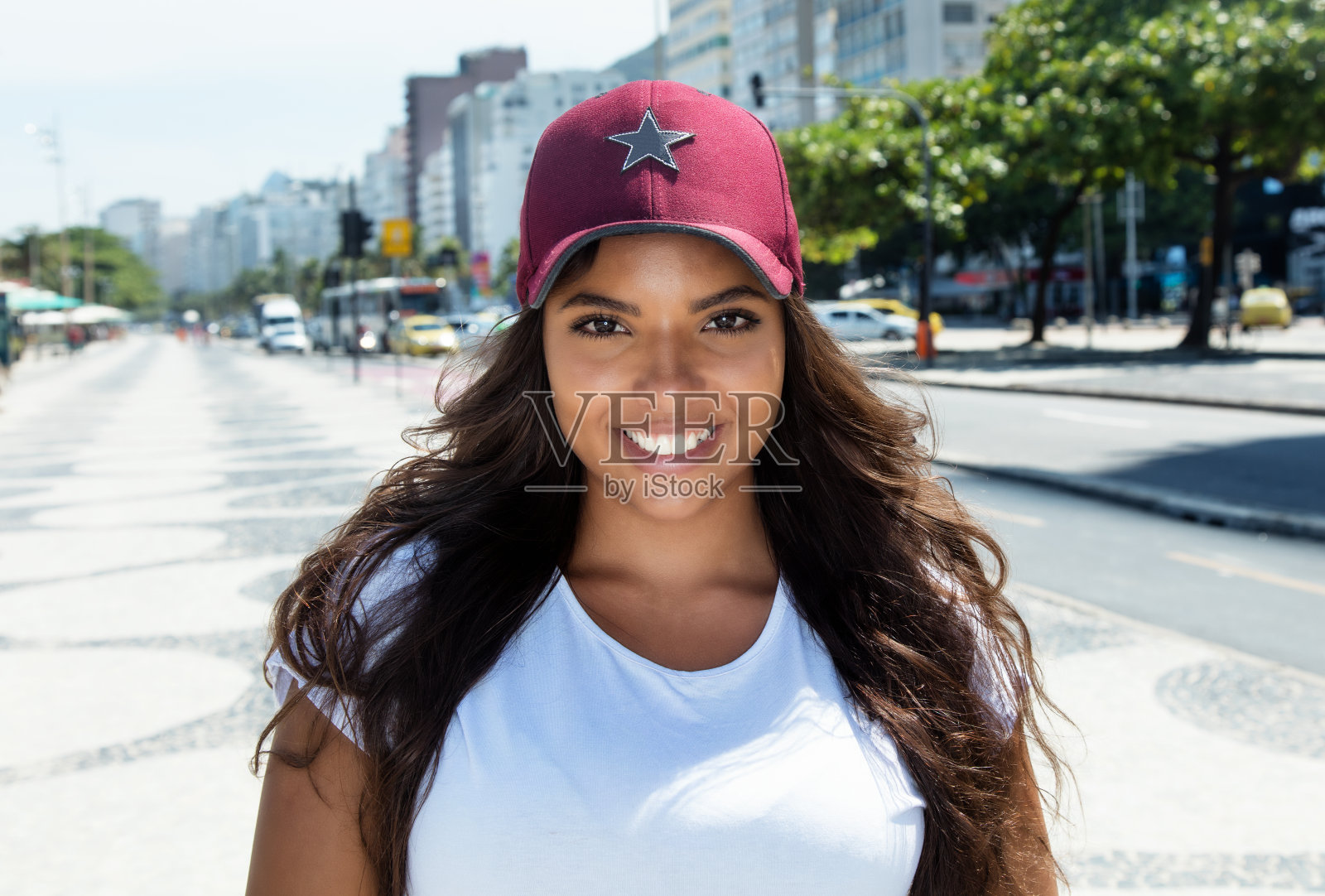 戴着棒球帽的拉丁美洲笑女人照片摄影图片