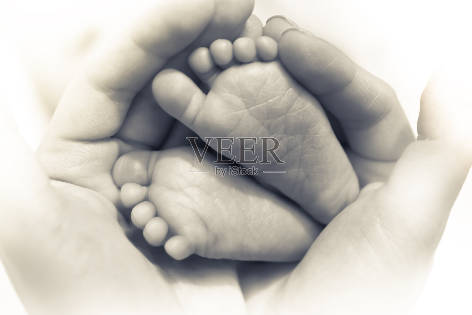 新生儿的脚在母亲的手中象征着关怀和父母的爱在黑色和白色照片摄影图片