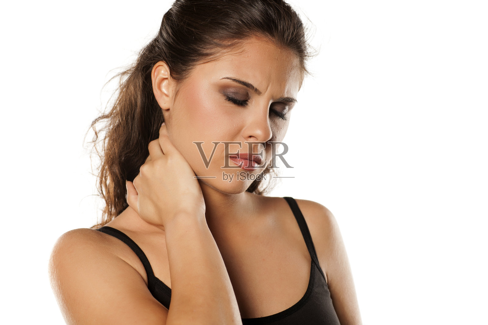 年轻漂亮的黑发姑娘在按摩她的脖子照片摄影图片