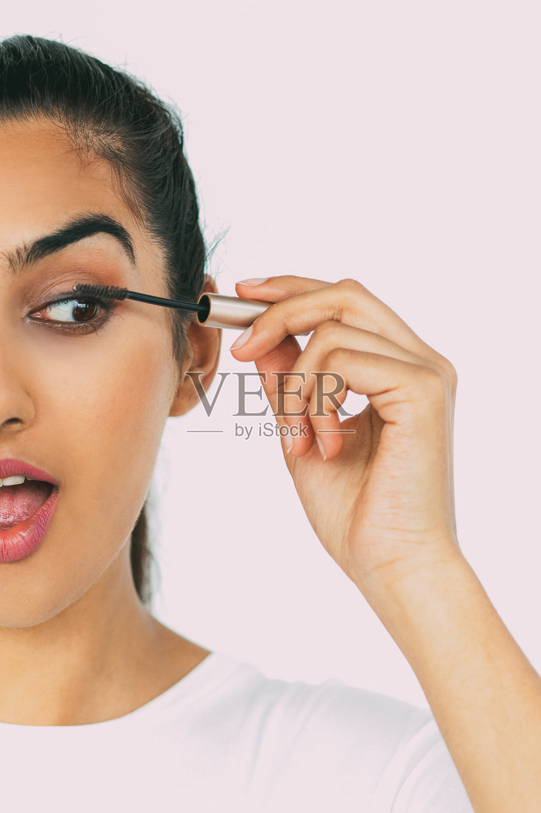 惊讶的印度女人涂睫毛膏照片摄影图片