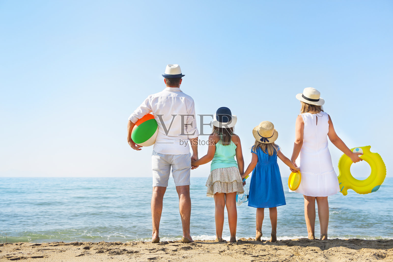 一个家庭和两个孩子在海滩上的肖像。假日及旅游概念照片摄影图片