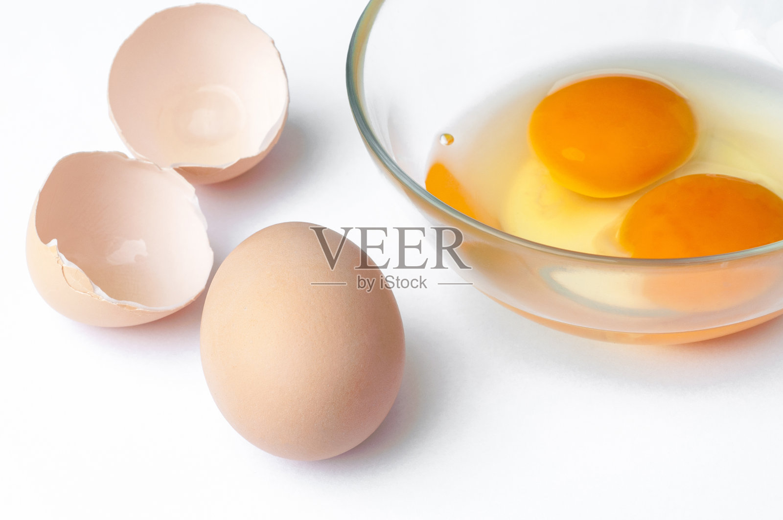 鸡蛋，蛋壳和生蛋黄在玻璃上的特写孤立在白色的背景照片摄影图片