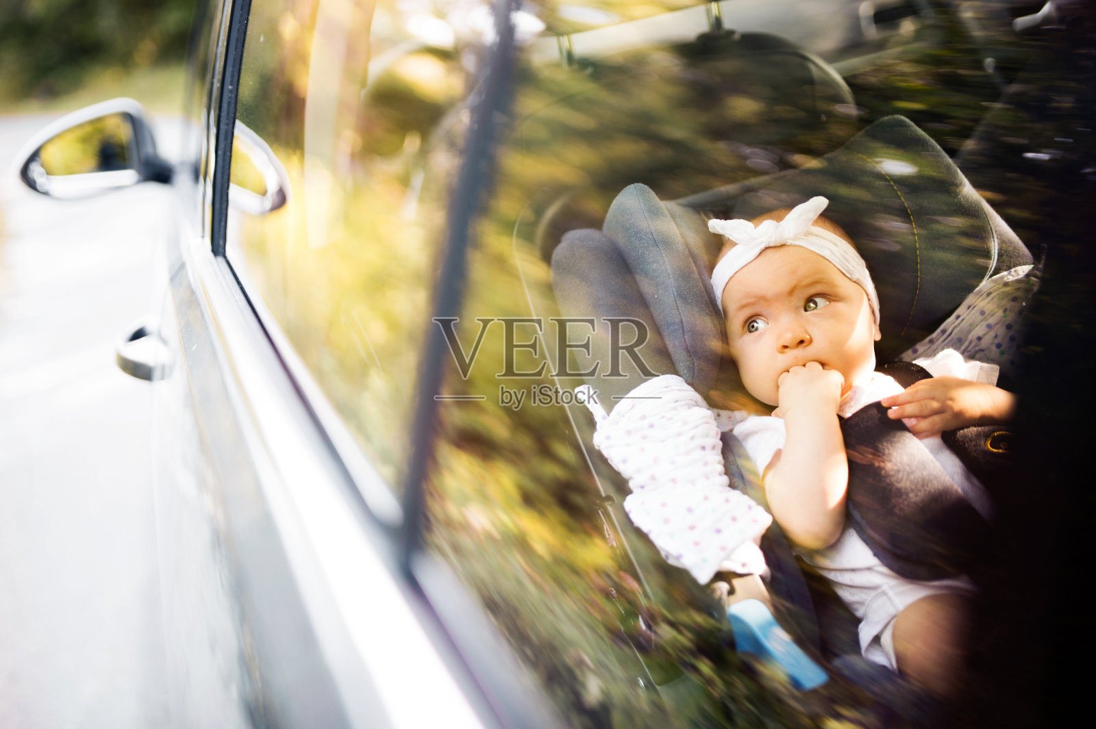 小婴儿用安全带系在安全座椅上。照片摄影图片