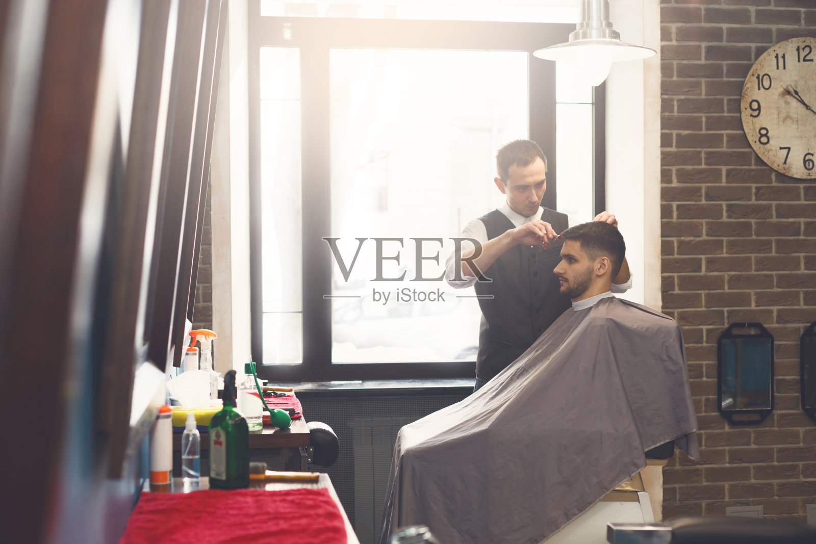 理发师在理发店里给一个男人理发照片摄影图片