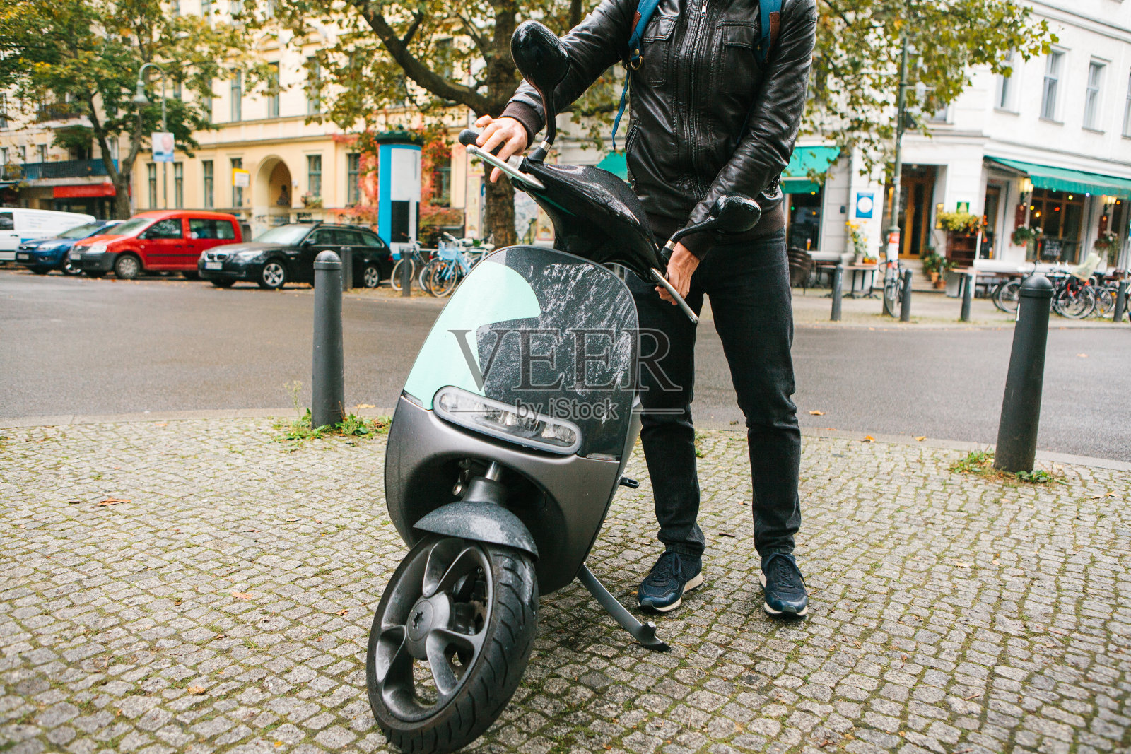 游客登上了一辆电动踏板车。在这个城市，一种很受欢迎的交通工具叫做电动踏板车。背景是柏林的一条街。照片摄影图片