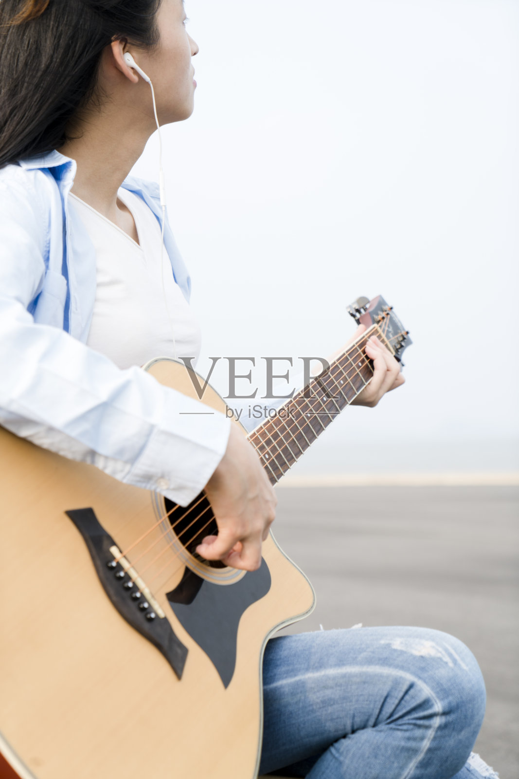 女人在路上弹吉他的特写照片摄影图片