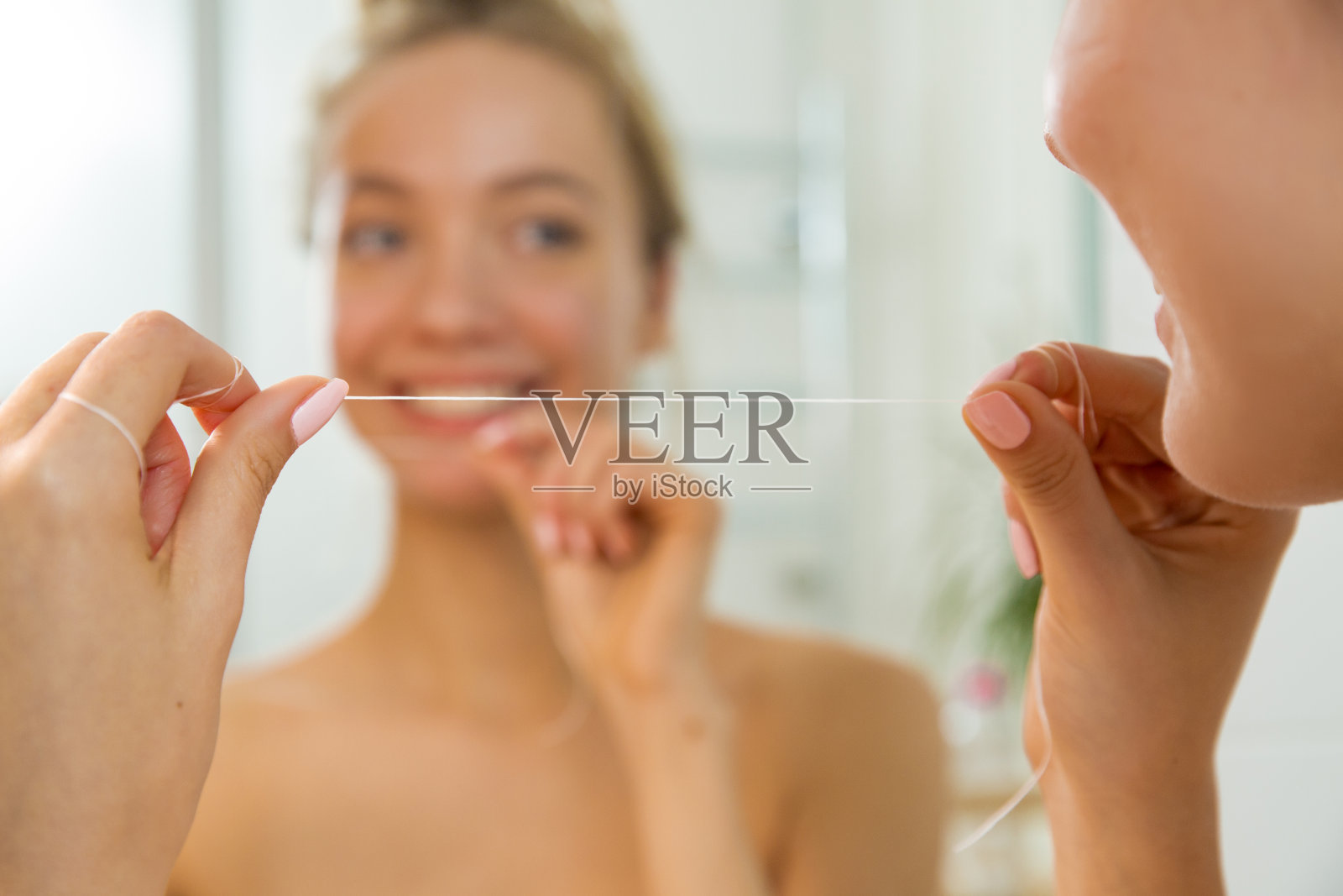 年轻漂亮的女人用牙线剔牙照片摄影图片