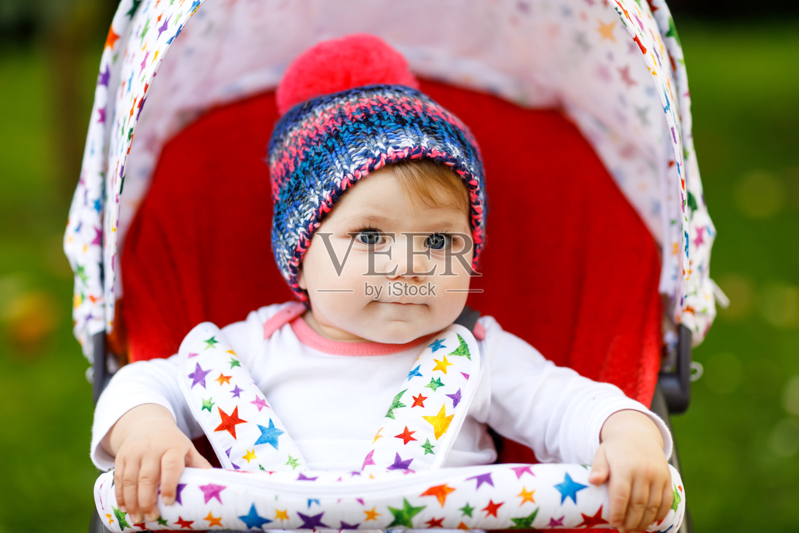 可爱的6个月的小女孩坐在时髦的婴儿车或婴儿车里等待妈妈照片摄影图片