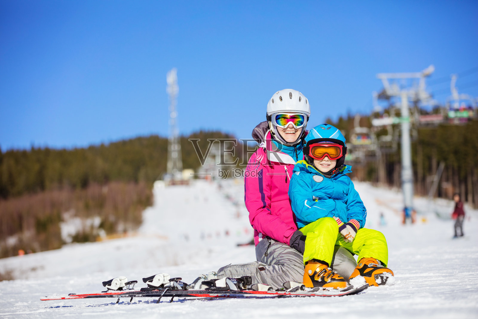 愉快的母亲和儿子在滑雪坡上休息照片摄影图片