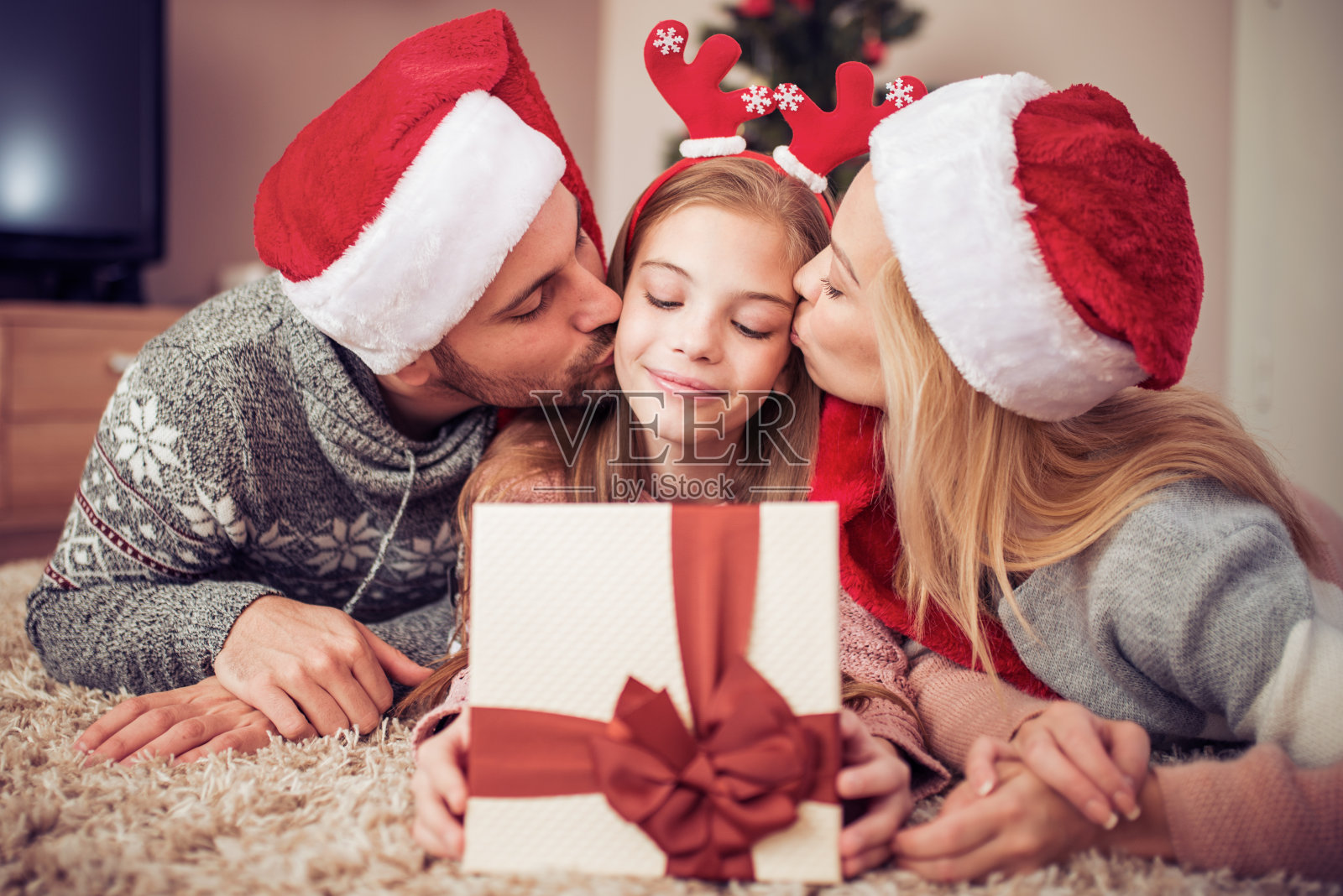 家人在圣诞树旁打开礼物照片摄影图片
