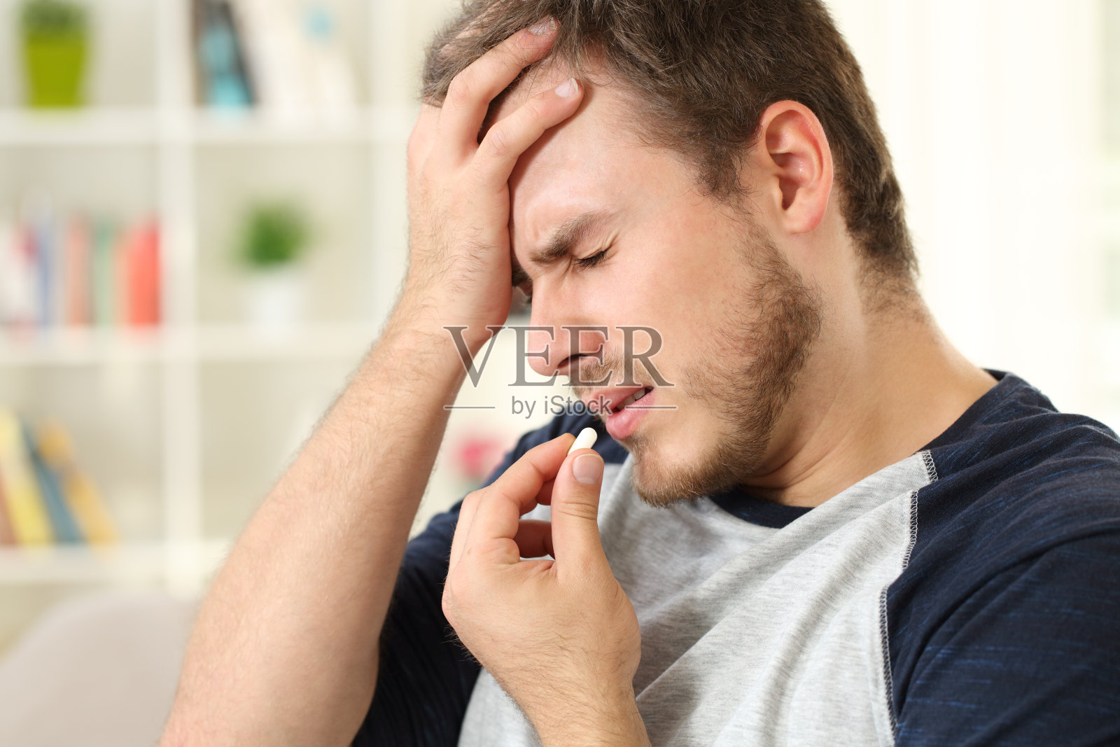 一个人在吃药片，头疼照片摄影图片