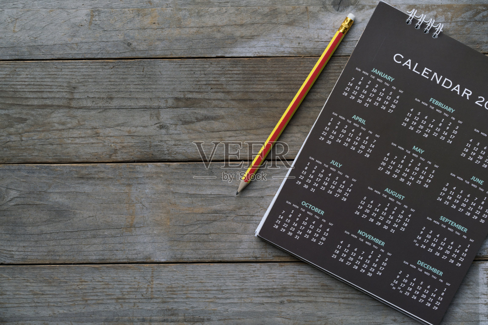 把日历和铅笔放在桌子上，计划商务会议或旅行计划的概念照片摄影图片