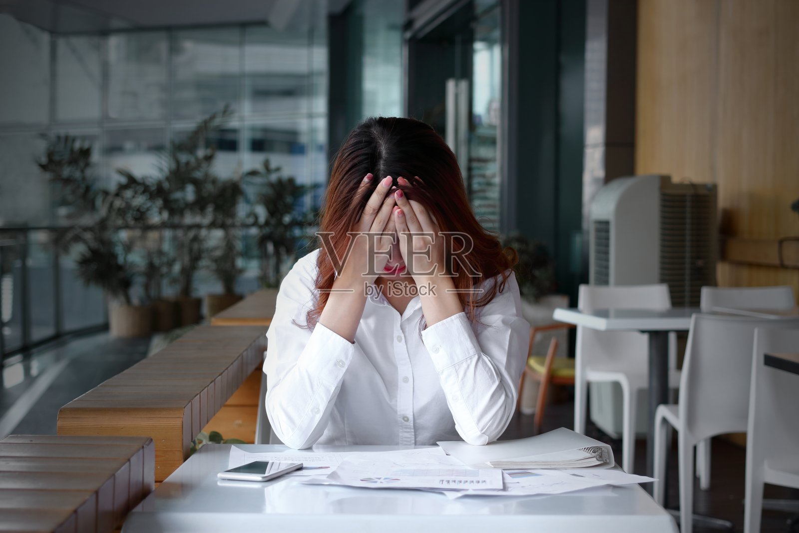 正面视图的压力沮丧的年轻亚洲商业妇女覆盖脸与手在办公室的桌子上照片摄影图片
