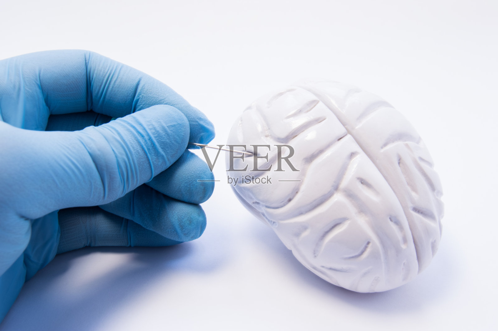 脑组织活检的概念。外科医生拿着穿刺针准备刺穿大脑捕捉神经细胞。脑病的侵入性诊断，如帕金森病照片摄影图片