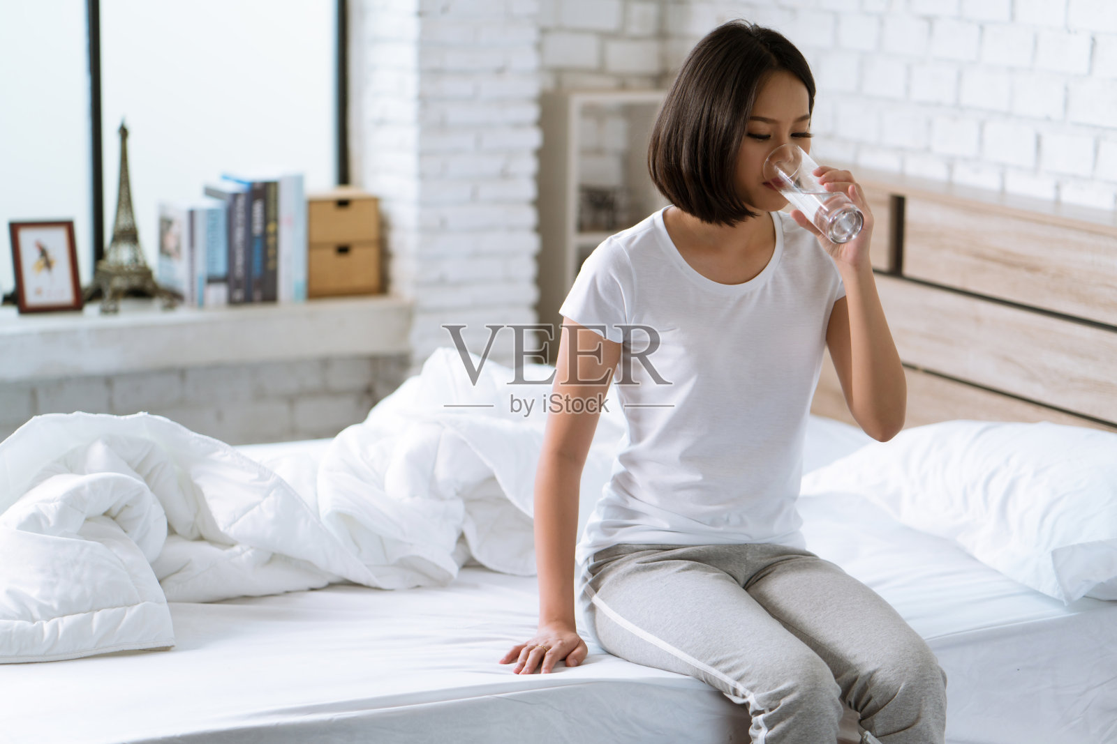 亚洲女性早上醒来后会喝水。照片摄影图片