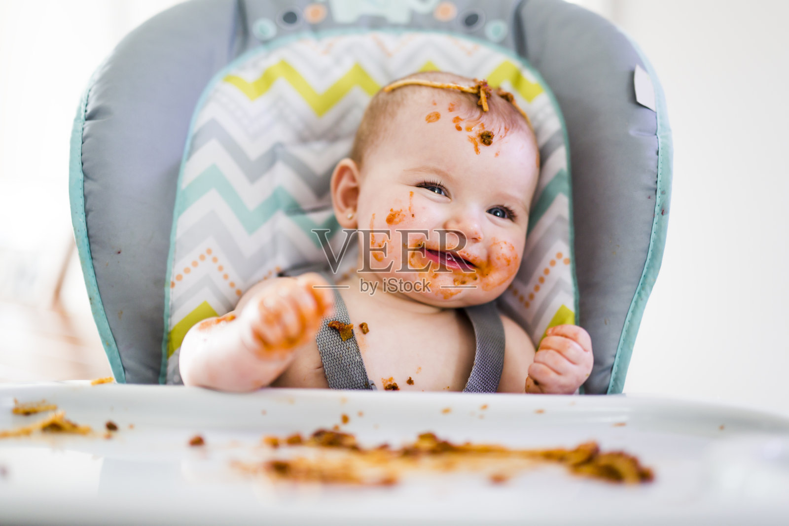 小婴儿在吃她的晚餐，弄得一团糟照片摄影图片