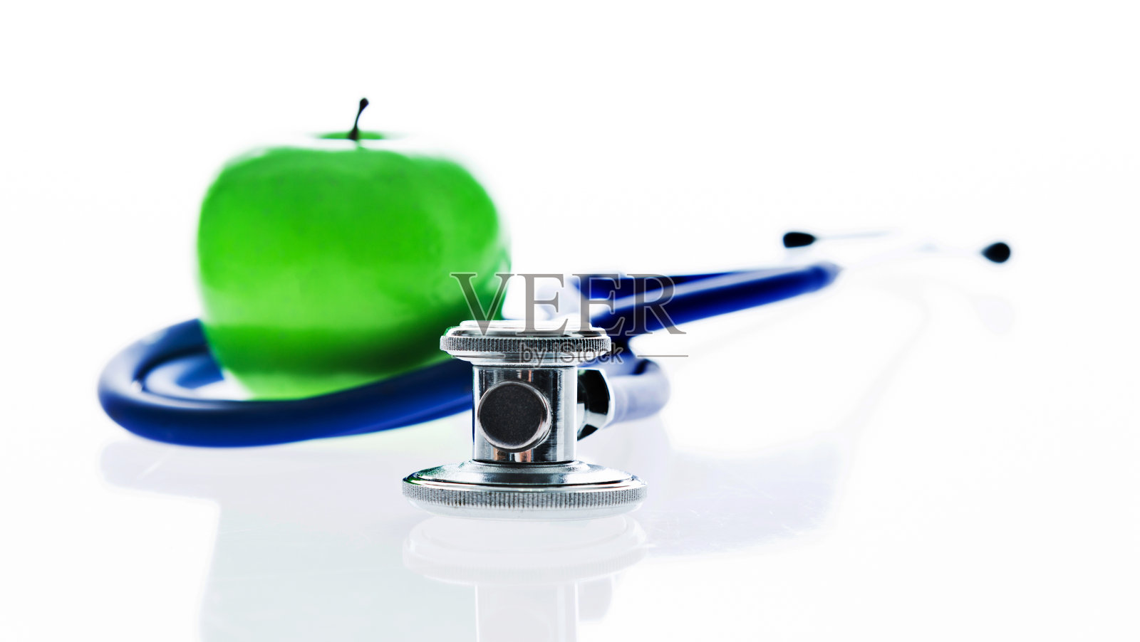 听诊器和绿苹果在白色的背景照片摄影图片