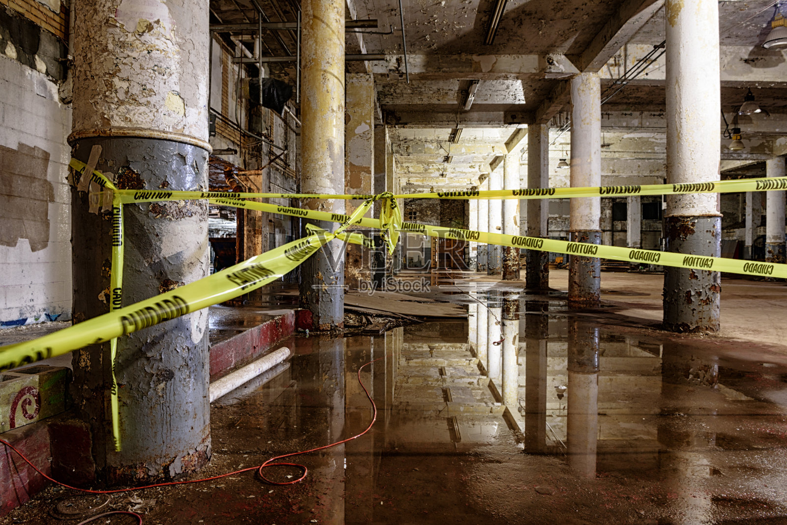 废弃的工业大楼，潮湿的地板，小心胶带照片摄影图片