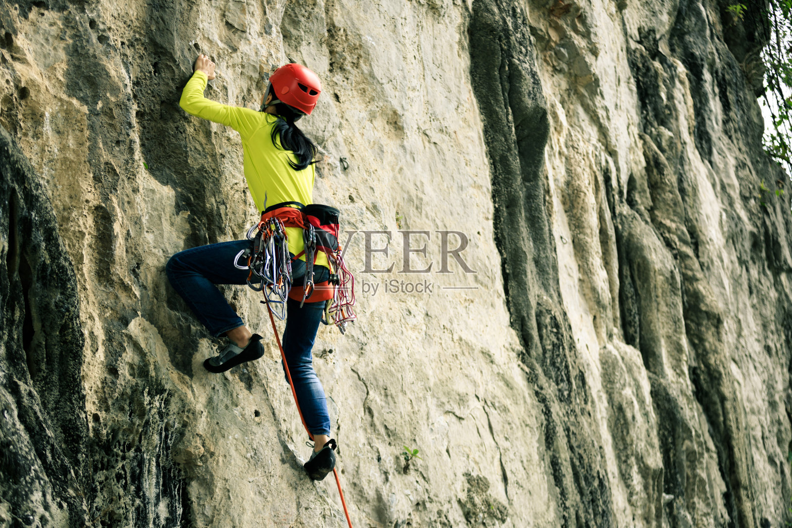 女攀岩者正在攀登悬崖照片摄影图片