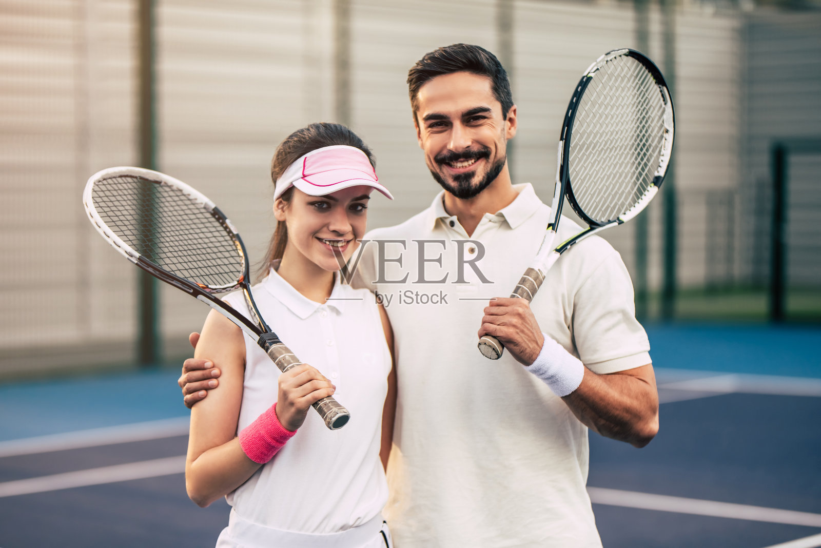 一对情侣在网球场上。照片摄影图片