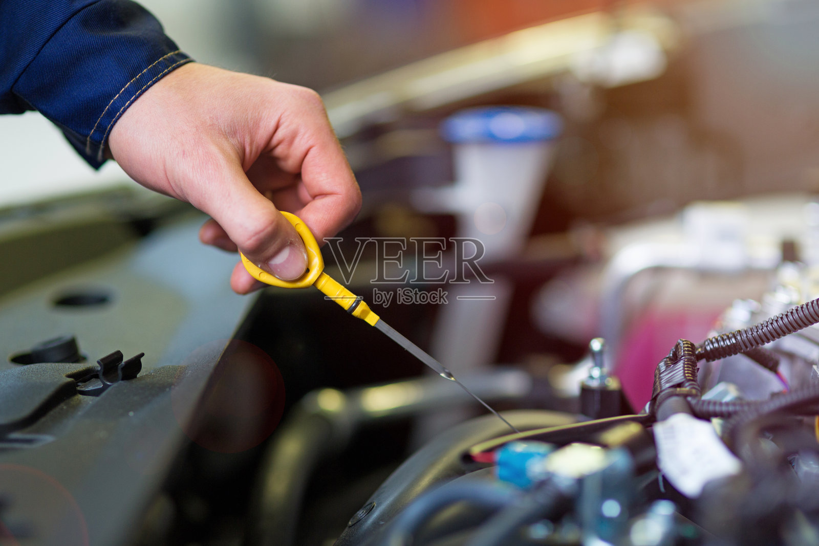 机械师在汽车修理厂检查机油照片摄影图片
