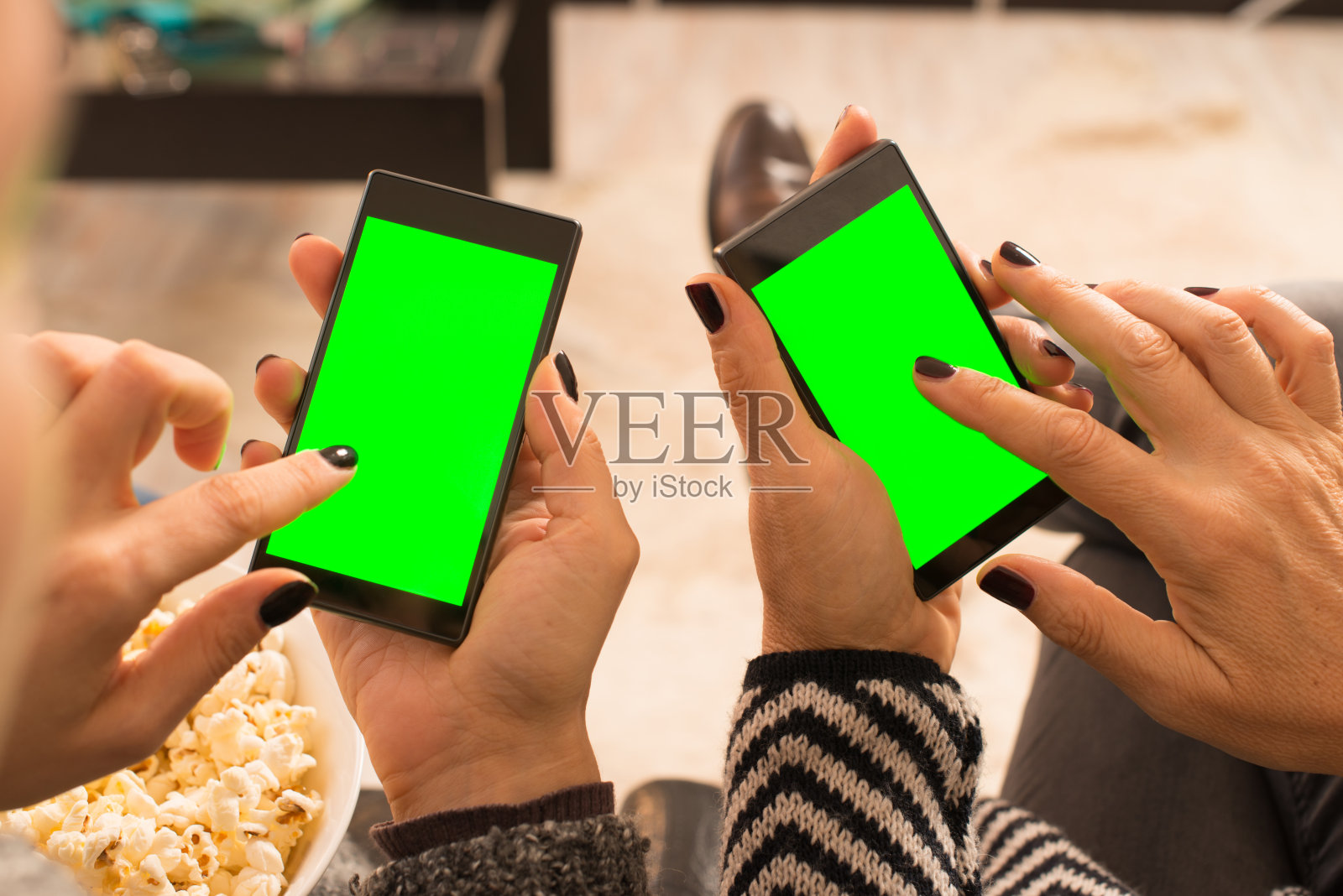 两个成年女性使用带绿屏的智能手机照片摄影图片