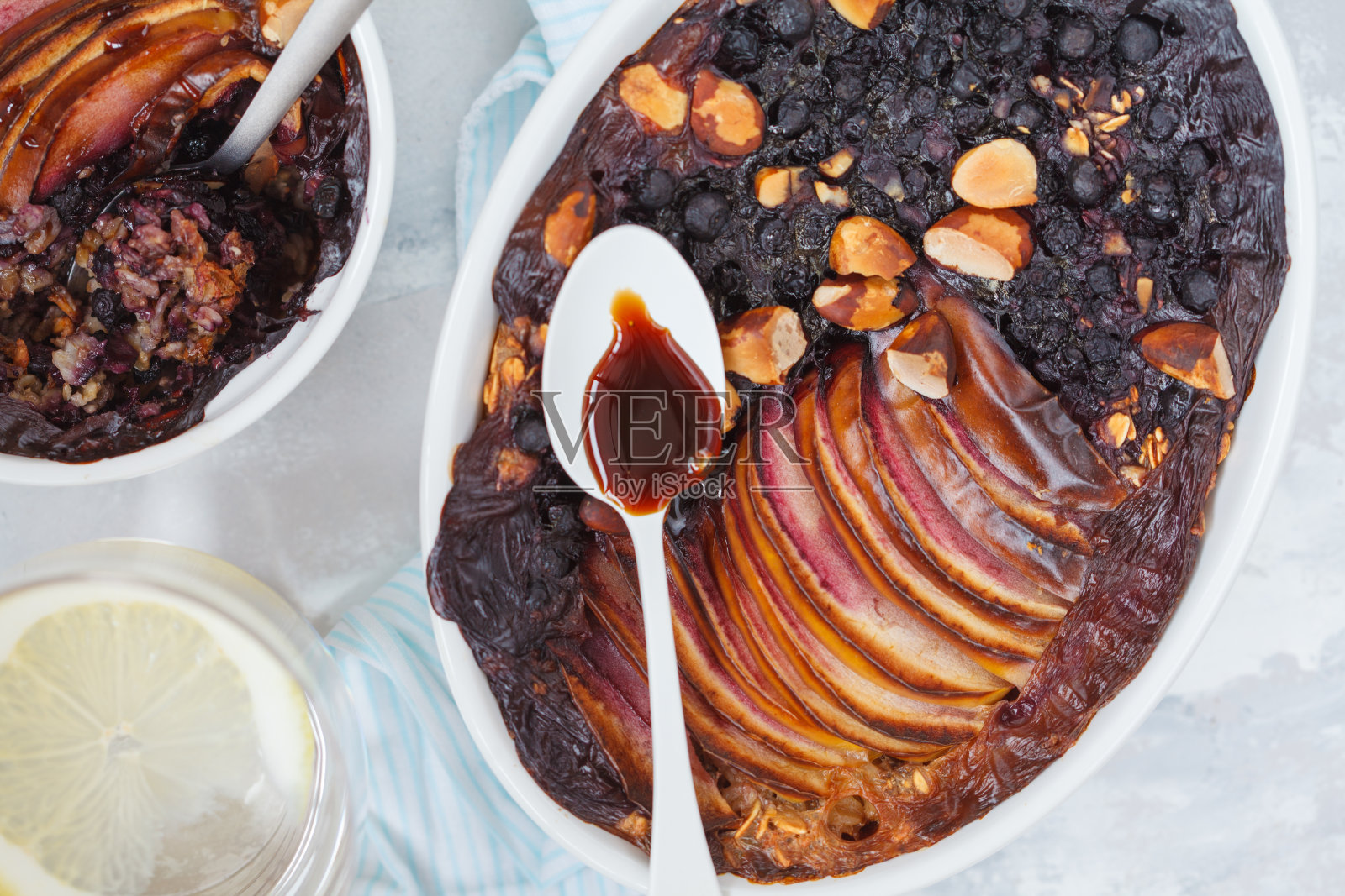 纯素烤燕麦片，苹果，蓝莓，巴西坚果和枣糖浆，俯视图照片摄影图片