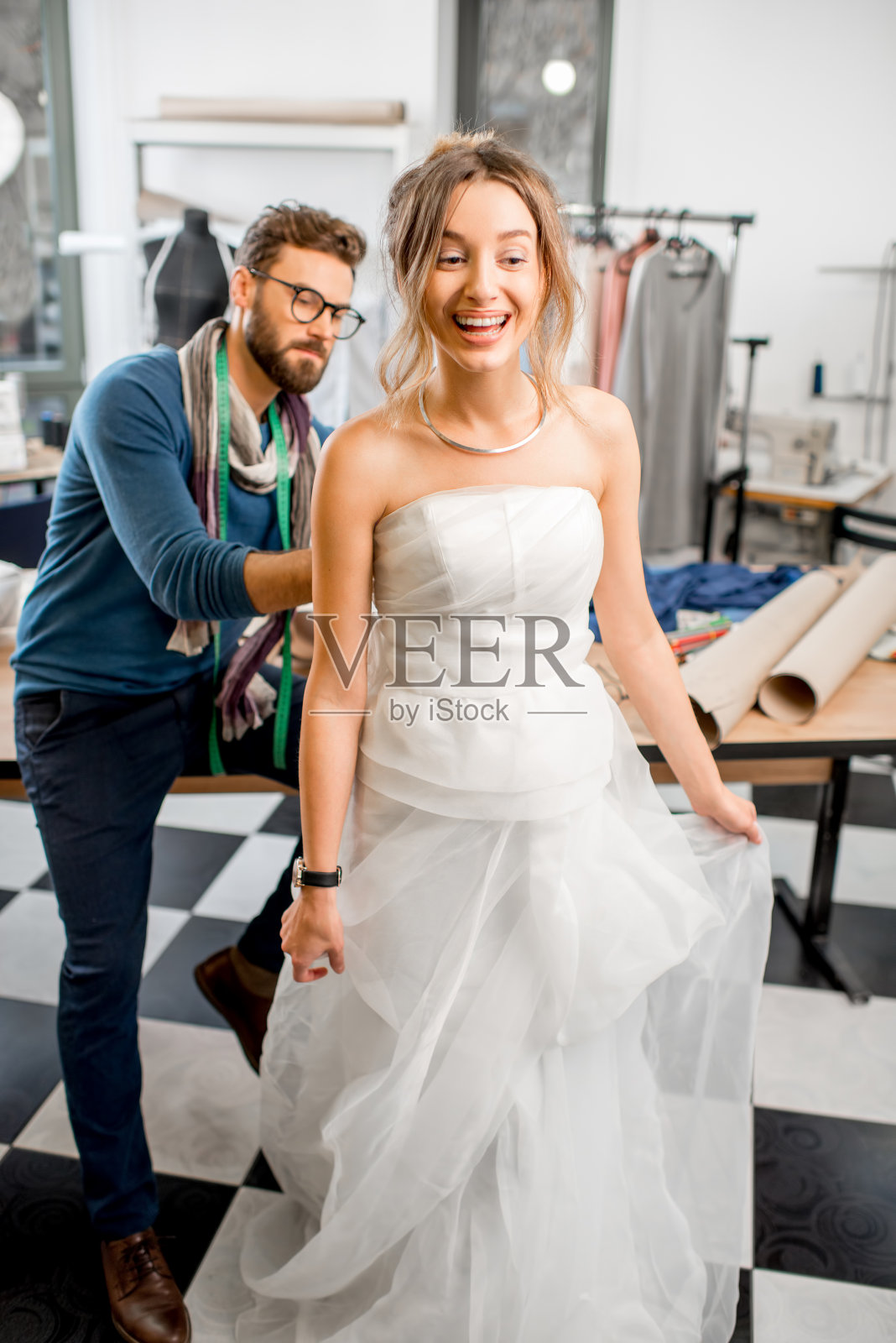 在裁缝工作室试穿婚纱的女人照片摄影图片