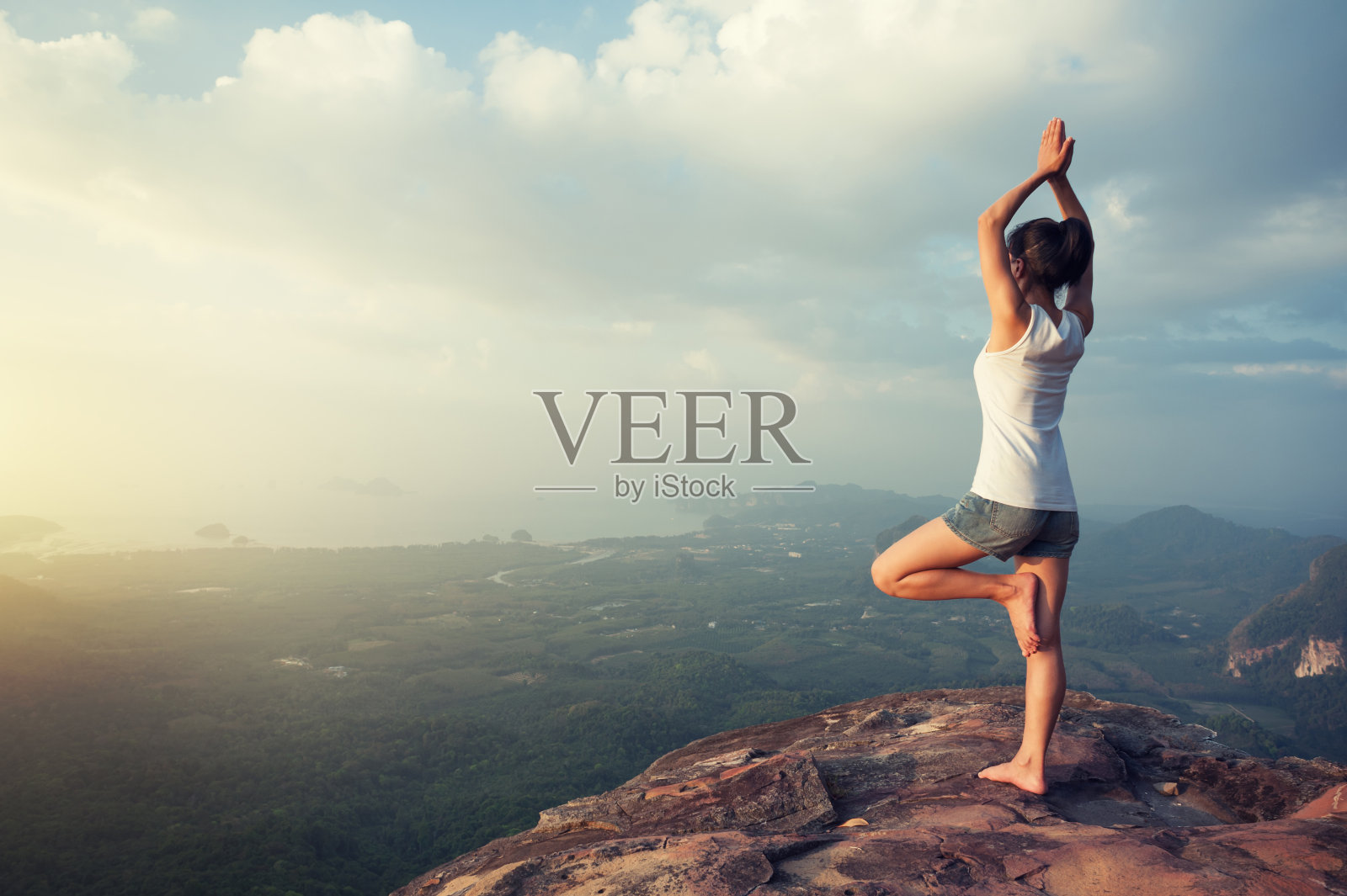 一名女子在山顶悬崖边练习瑜伽照片摄影图片